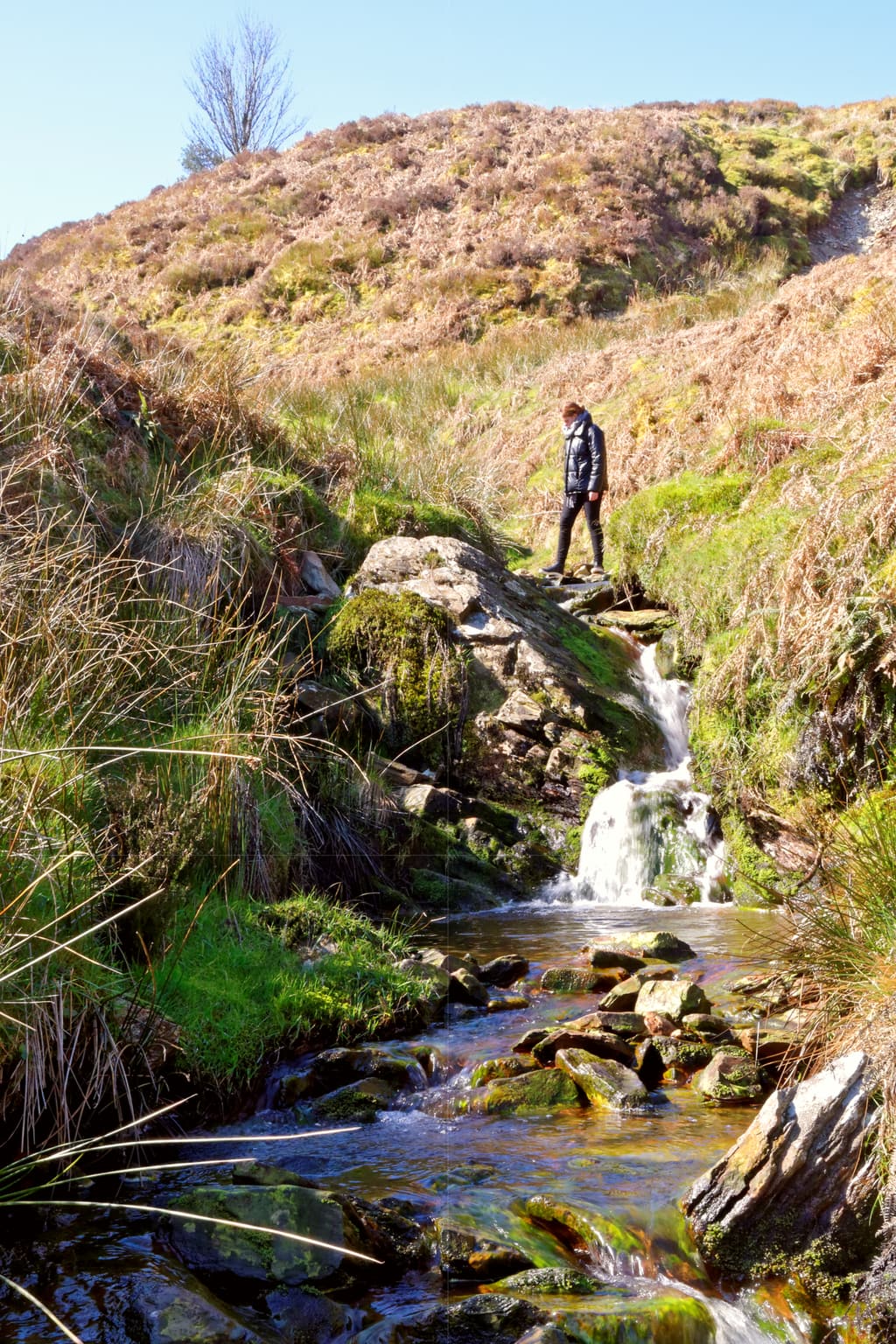 Hiking over a stream in the mountains of Snowdonia